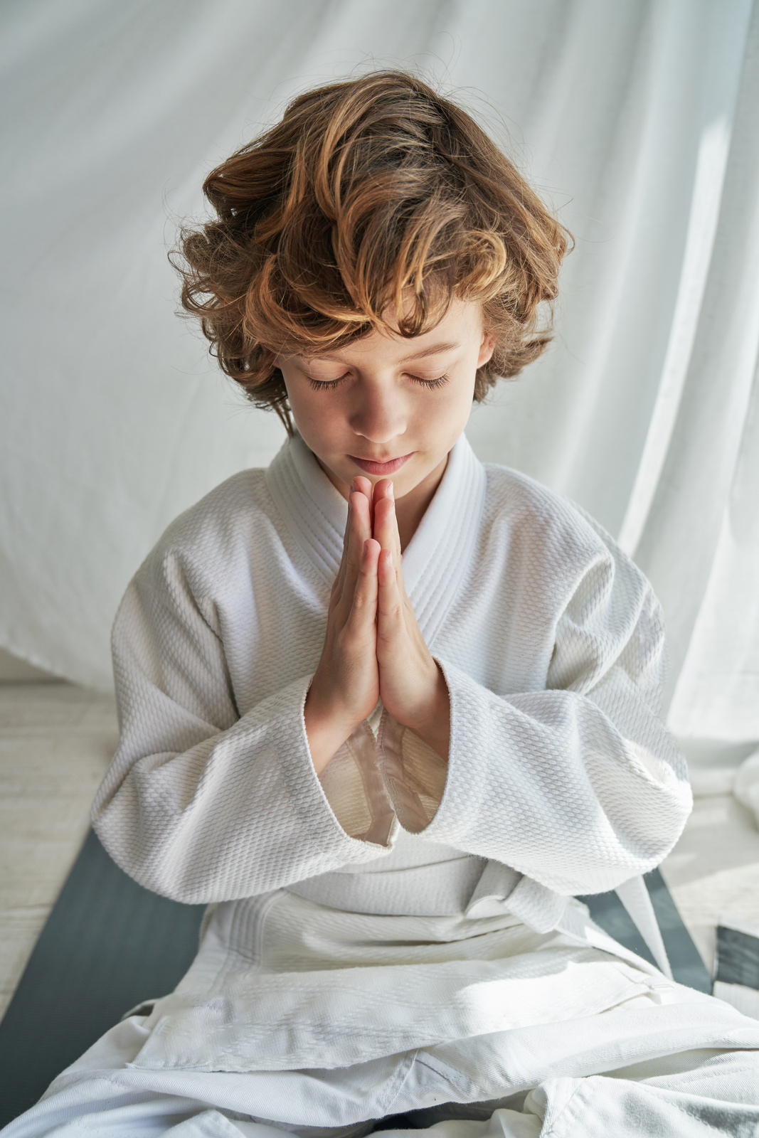 Calm kid meditating in Padmasana while practicing yoga